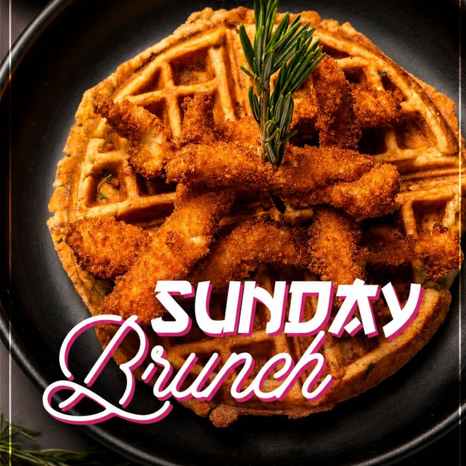 Crispy fried chicken tenders piled over a golden waffle on a black plate, garnished with rosemary and labeled Sunday Brunch.