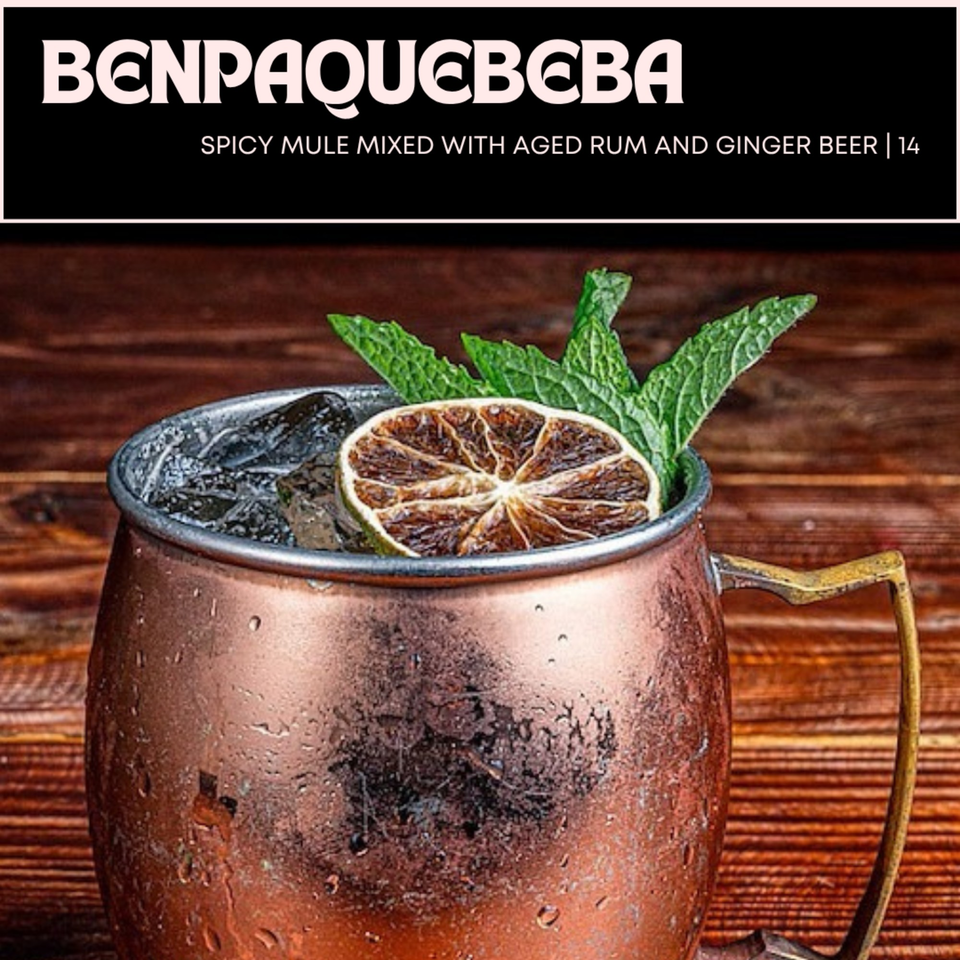 A copper mug filled with ice, a dried lime slice, and fresh mint leaves, on a wooden surface.